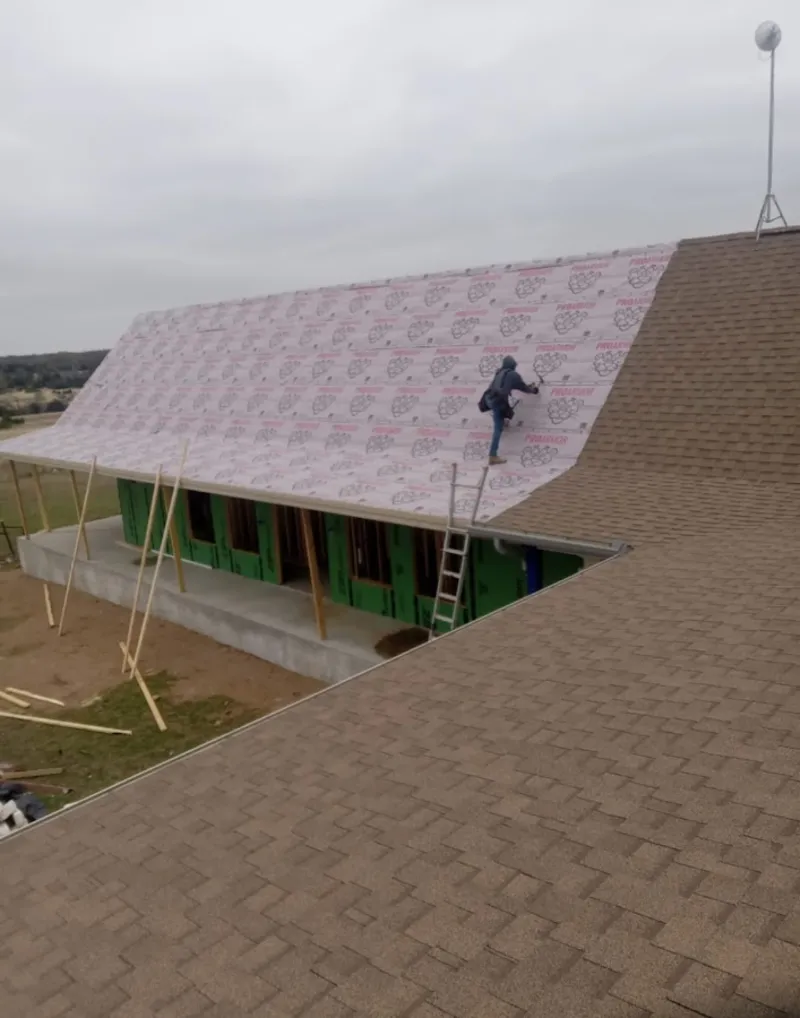 Worker preparing underlayment for a metal roof installation in Wyoming